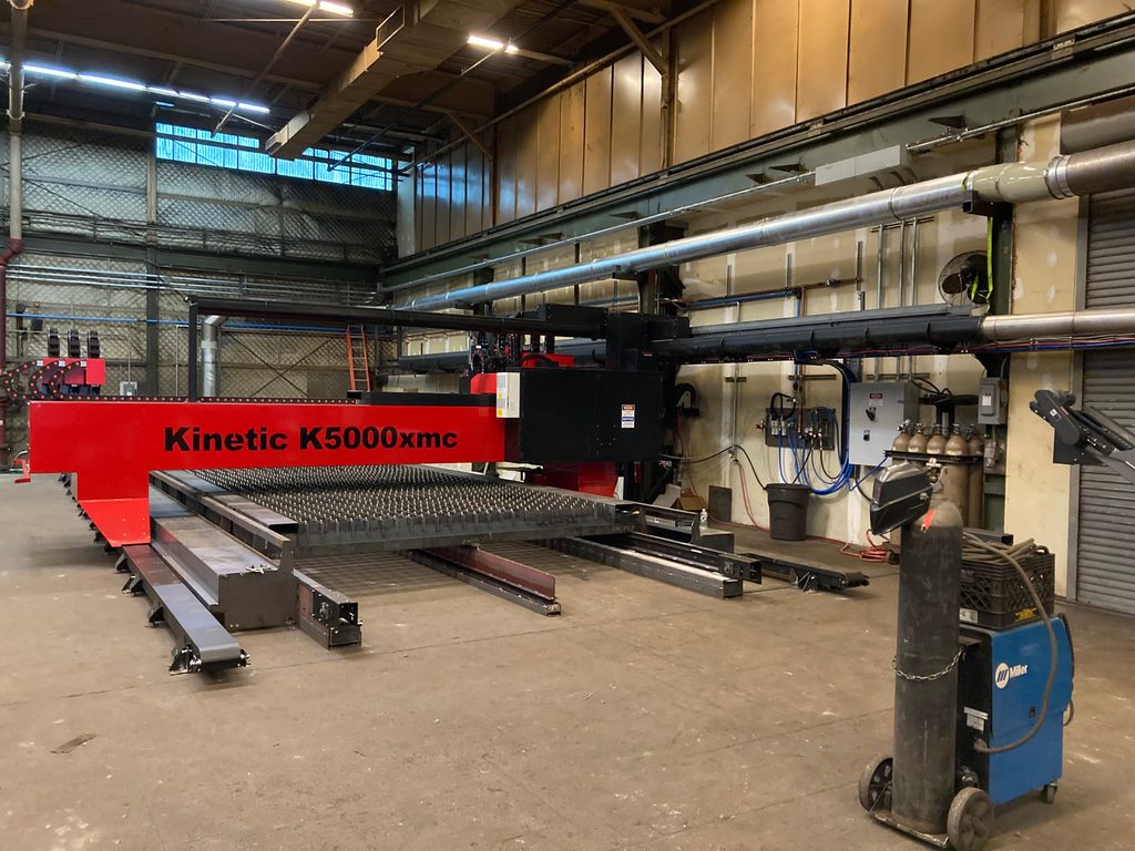 Kinetic K5000XMC bolt-forming machine on the plant floor during commissioning.